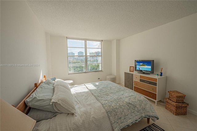 bedroom with light tile patterned floors and a textured ceiling