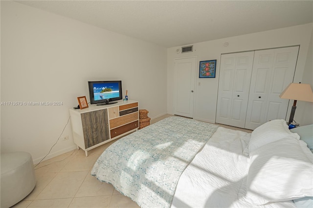 bedroom with a closet and light tile patterned flooring