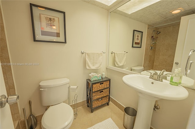 bathroom featuring tile patterned floors, toilet, and tiled shower