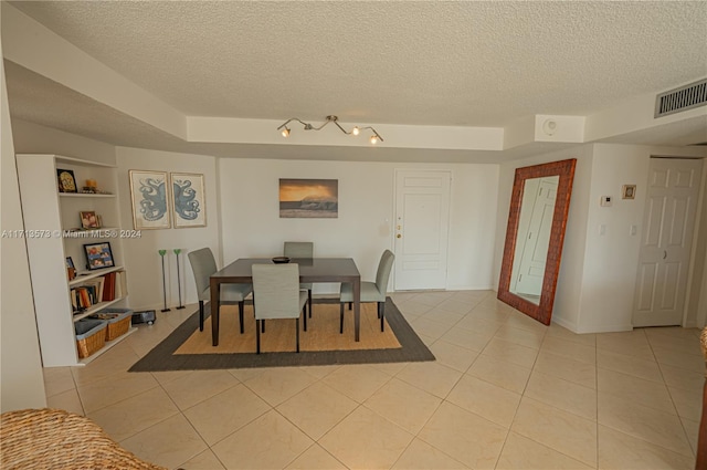 tiled dining space with a textured ceiling