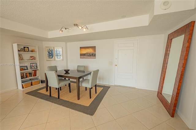 dining space featuring light tile patterned floors, a textured ceiling, and built in features