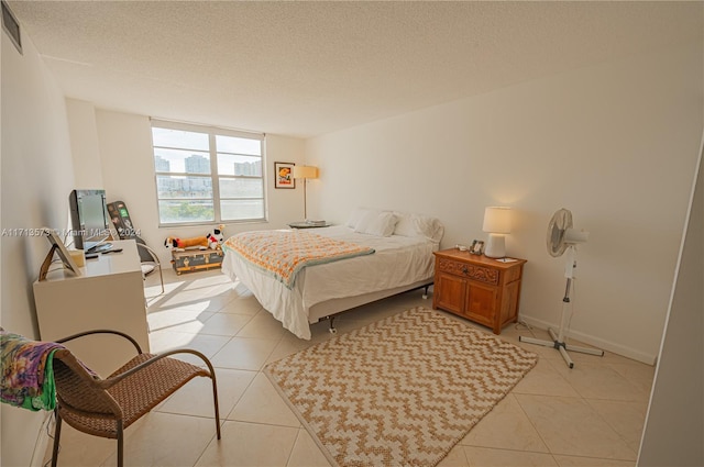 bedroom featuring light tile patterned floors and a textured ceiling