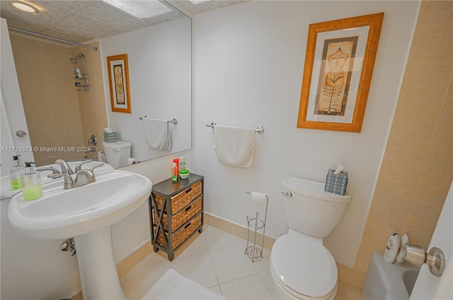 full bathroom with sink, tile patterned flooring, tiled shower / bath, and toilet