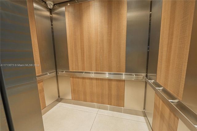 spacious closet featuring light tile patterned floors and elevator