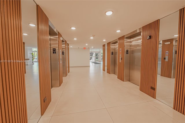 hall with elevator and light tile patterned flooring