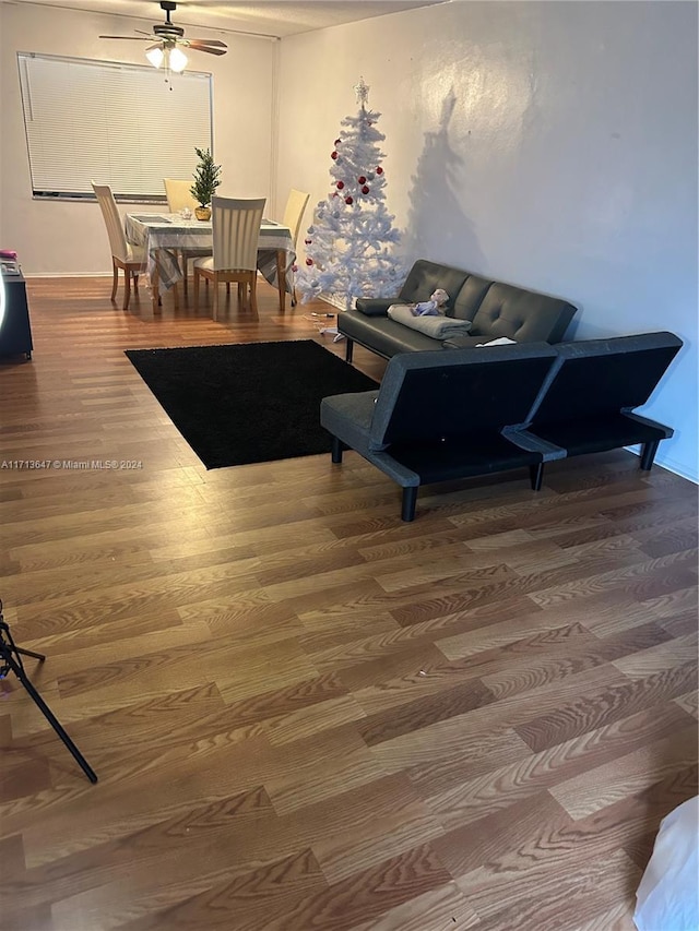 living room featuring hardwood / wood-style floors and ceiling fan