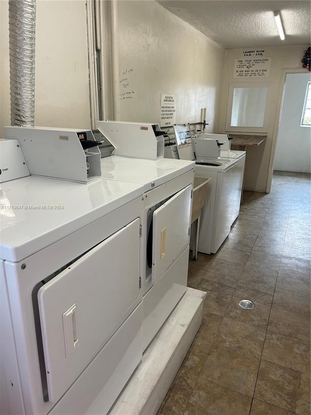 clothes washing area featuring independent washer and dryer and a textured ceiling