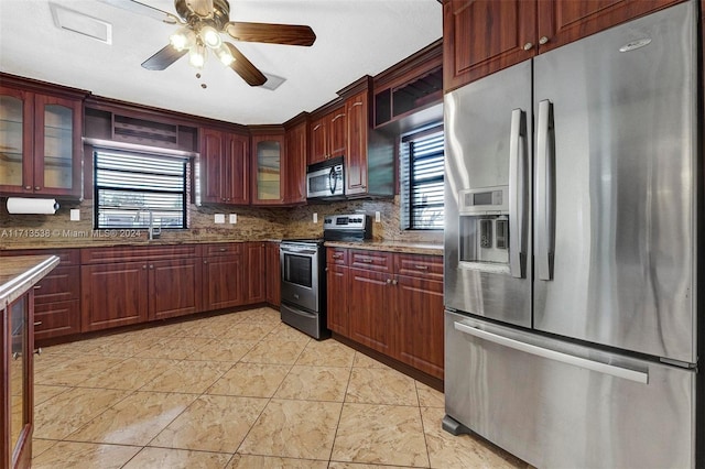 kitchen featuring decorative backsplash, ceiling fan, plenty of natural light, and stainless steel appliances