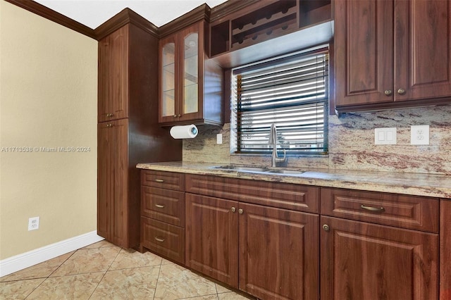 kitchen featuring light stone countertops, backsplash, light tile patterned flooring, and sink