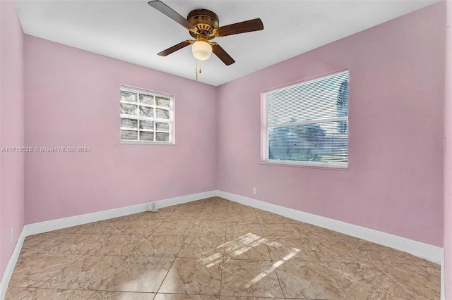 empty room with ceiling fan and plenty of natural light