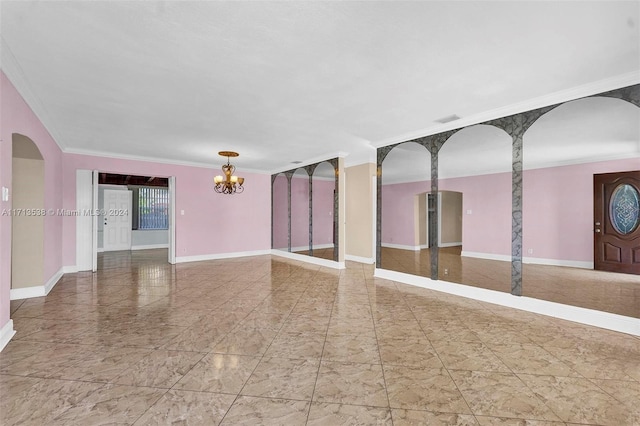 empty room with crown molding and a chandelier