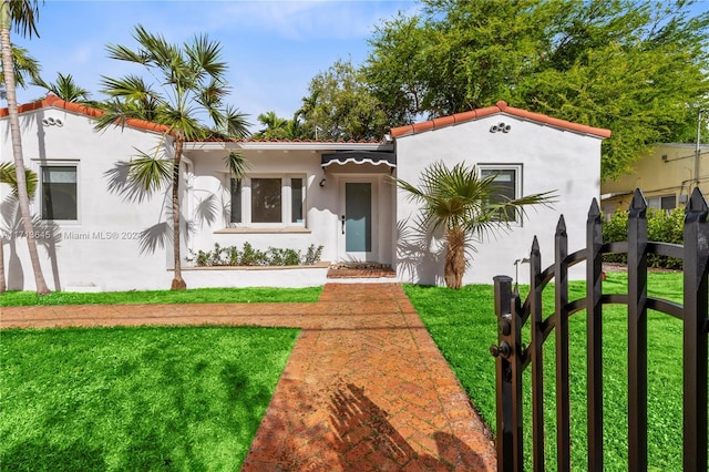 mediterranean / spanish home featuring a front lawn