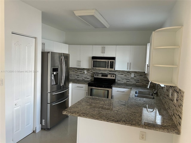 kitchen featuring kitchen peninsula, appliances with stainless steel finishes, and white cabinets