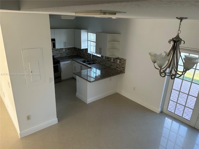 kitchen featuring kitchen peninsula, white cabinetry, sink, and decorative backsplash