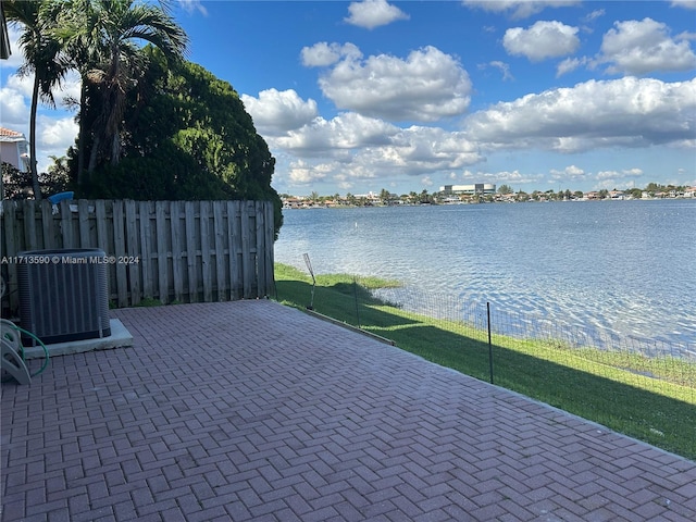 view of patio with a water view and central AC