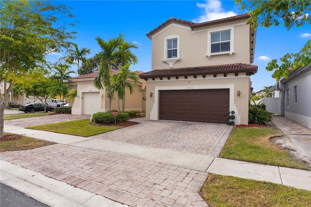 mediterranean / spanish home featuring a garage and a front lawn