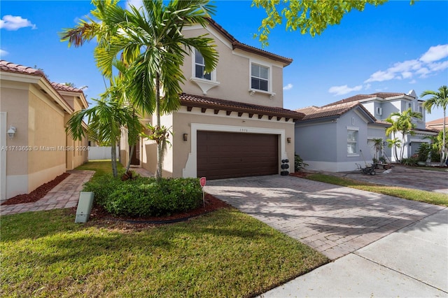 mediterranean / spanish house with a front lawn and a garage