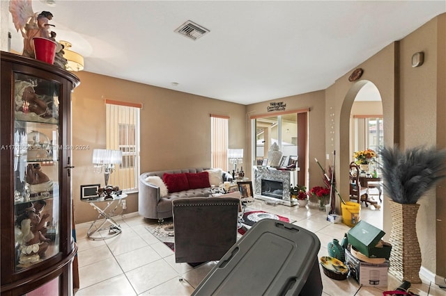 living room with a fireplace and light tile patterned flooring