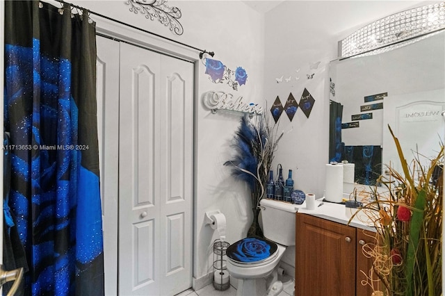 bathroom with tile patterned flooring, vanity, and toilet