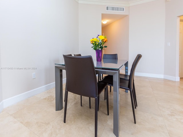 dining area with crown molding and light tile patterned flooring