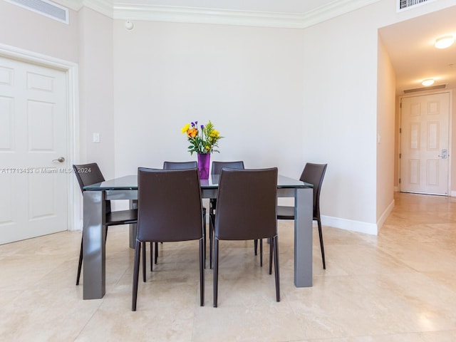 dining space featuring crown molding and light tile patterned flooring