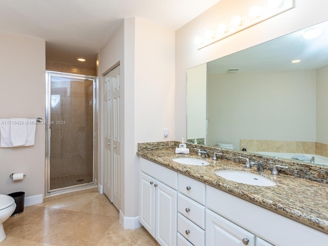 bathroom featuring tile patterned flooring, vanity, toilet, and an enclosed shower