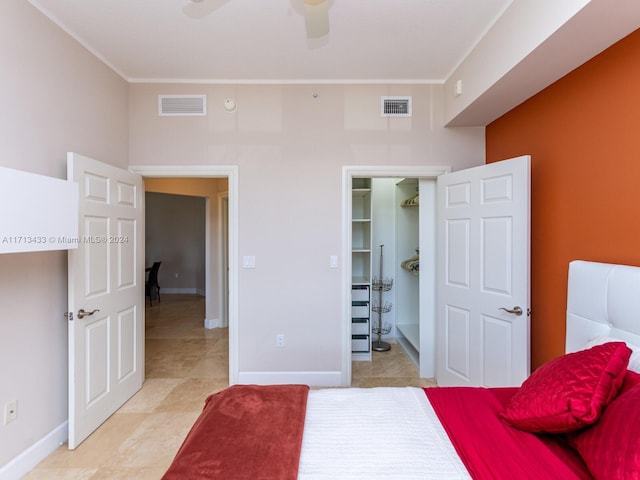 bedroom with ceiling fan, light tile patterned flooring, and a spacious closet