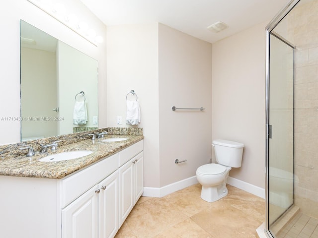 bathroom featuring vanity, toilet, and a shower with shower door