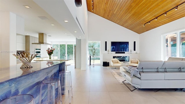 tiled living room with wood ceiling, track lighting, and high vaulted ceiling