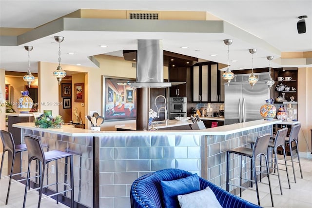 kitchen featuring hanging light fixtures, island exhaust hood, light tile patterned flooring, and stainless steel appliances