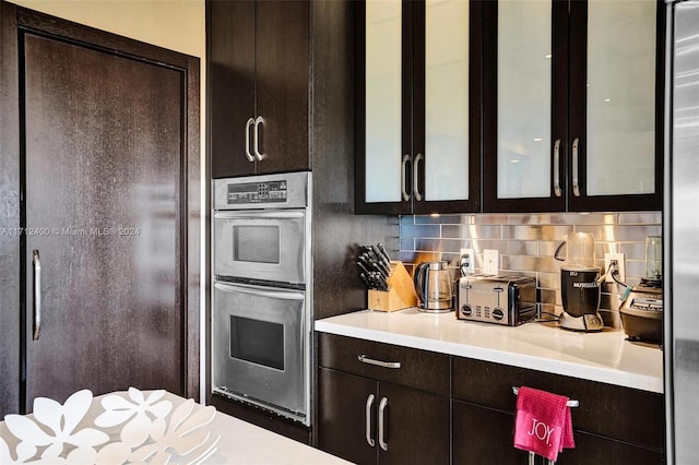 kitchen featuring stainless steel appliances, backsplash, and dark brown cabinetry