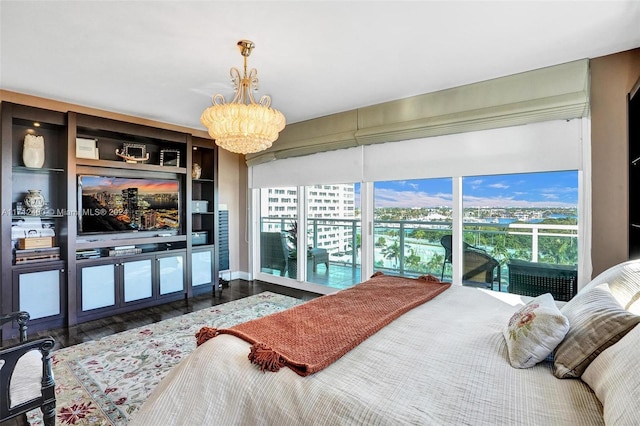 bedroom featuring an inviting chandelier, dark hardwood / wood-style flooring, and access to outside