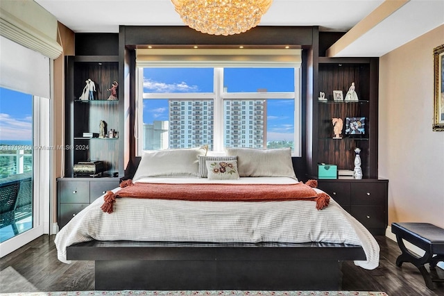 bedroom with multiple windows, dark wood-type flooring, and a chandelier