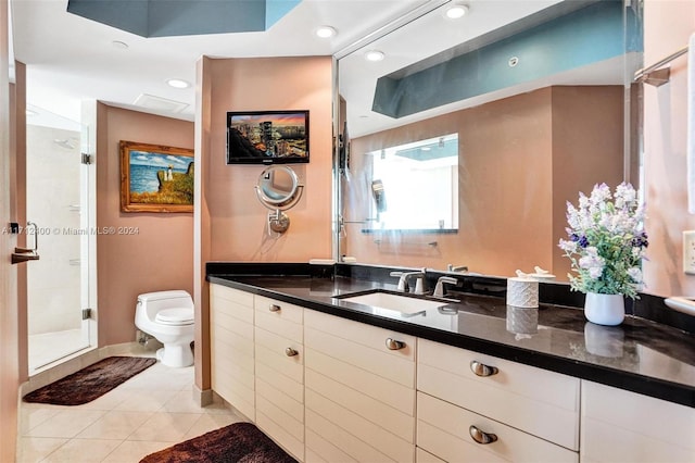 bathroom with vanity, a shower with door, tile patterned floors, and toilet