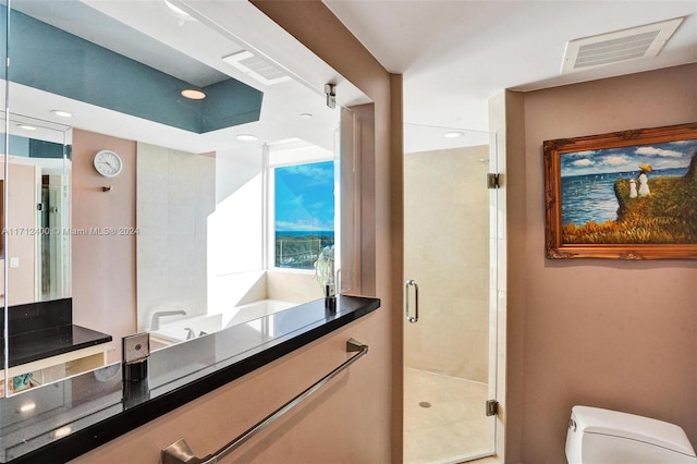 bathroom featuring vanity, toilet, and a shower with shower door