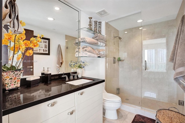 bathroom featuring tile patterned flooring, vanity, an enclosed shower, and toilet