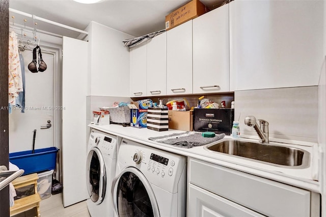 laundry area with cabinets, washer and clothes dryer, sink, and light tile patterned floors