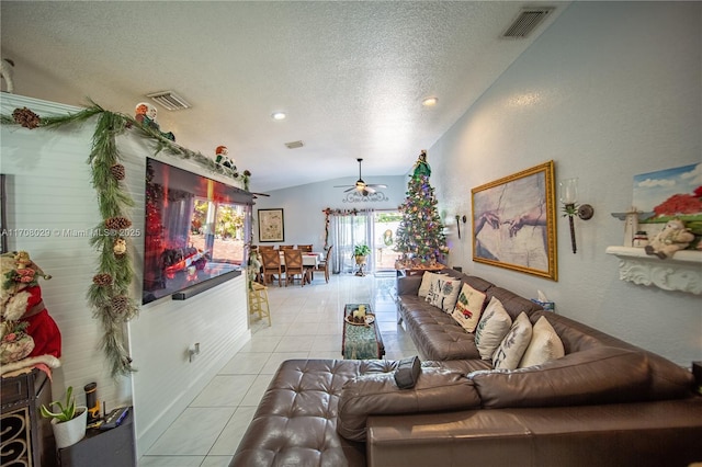 living area featuring lofted ceiling, light tile patterned floors, visible vents, and a textured ceiling