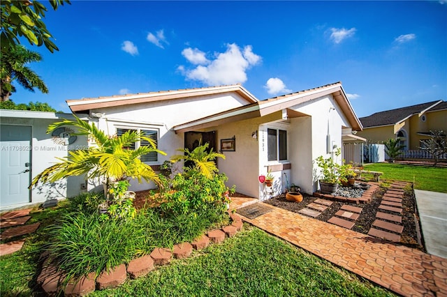 view of front of property featuring a front lawn and stucco siding