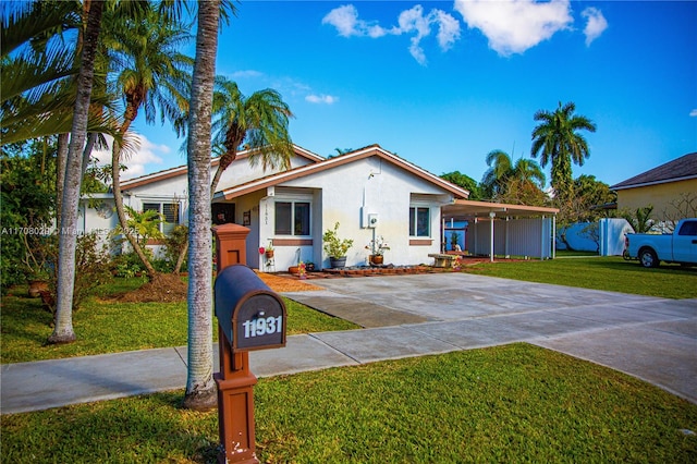 view of front of property featuring stucco siding, driveway, and a front lawn