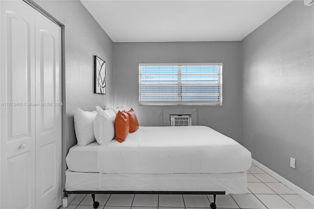 tiled bedroom with an AC wall unit and a closet