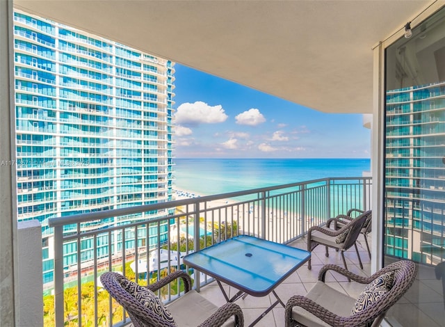 balcony featuring a water view and a view of the beach