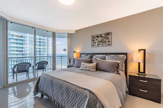 bedroom featuring access to exterior, expansive windows, and a water view