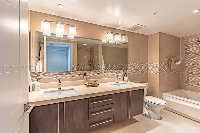 full bathroom with tile patterned flooring, tile walls, vanity, toilet, and tiled shower / bath