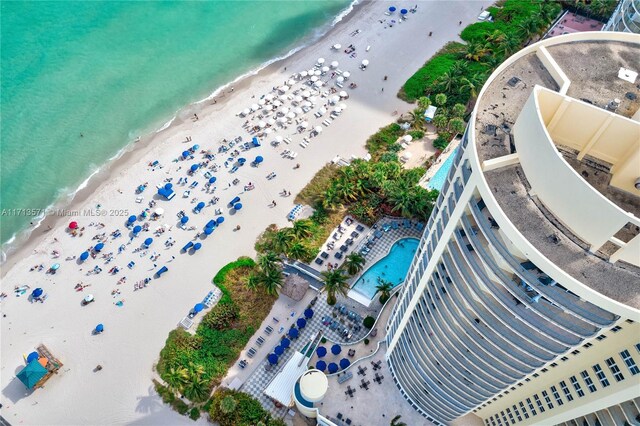 drone / aerial view with a water view and a beach view