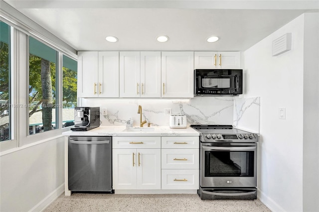 kitchen with white cabinets, sink, decorative backsplash, light stone countertops, and stainless steel appliances