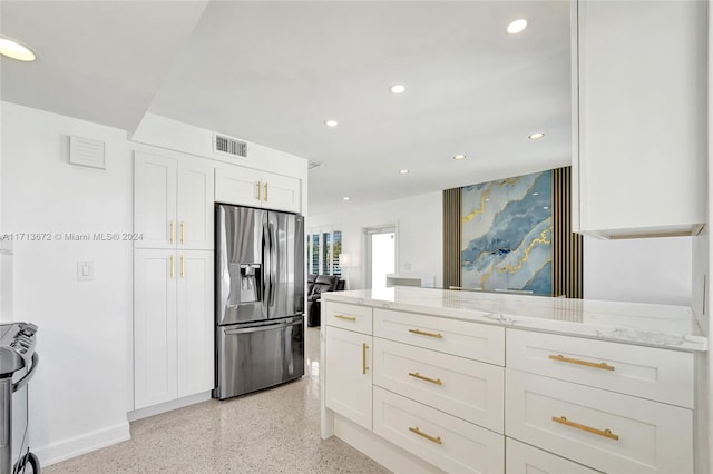 kitchen with light stone countertops, white cabinets, and stainless steel appliances