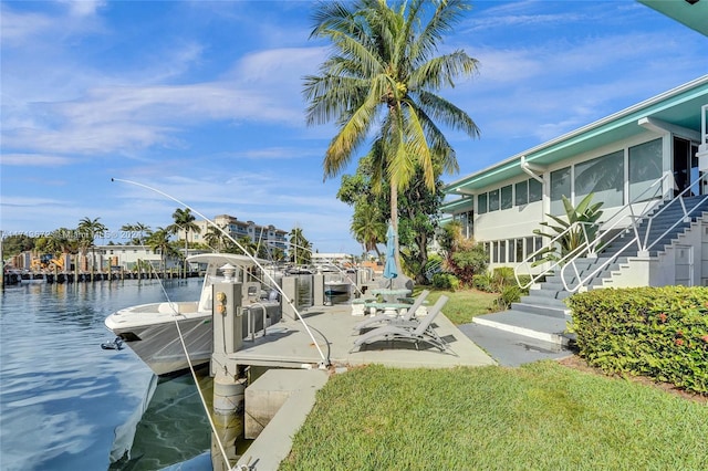 view of dock with a yard and a water view