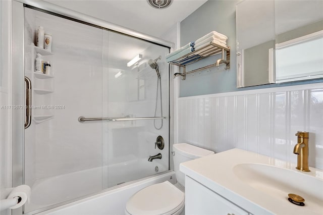 full bathroom featuring shower / bath combination with glass door, vanity, and toilet