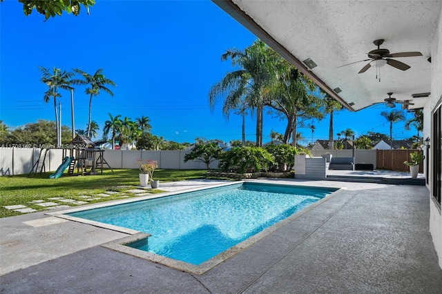 view of pool featuring a playground, a yard, and a patio